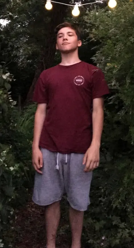 Oliver as a skinny teenager at school, standing in a garden